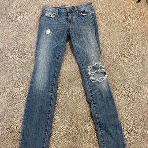 light wash ripped skinny jeans with cute piece of fabric sown under the knee rip